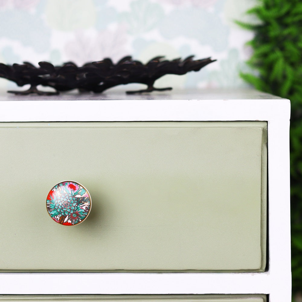 fargeglad keramikk knott dekorert med vakre tropiske planter i grønne og røde farger